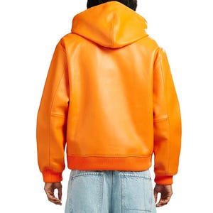 May include: Bright orange leather hooded jacket with ribbed cuffs and hem. The jacket features a classic bomber style with a hood and a smooth, glossy finish. The back view showcases the jacket's clean lines and vibrant color.