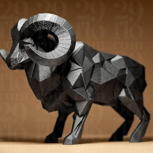 Könnte beinhalten: Schwarze geometrische Skulptur eines Widders mit großen, gebogenen Hörnern. Der Widder ist im Low-Poly-Stil dargestellt, mit vielen flachen, abgewinkelten Oberflächen, die seine Form bilden. Dekorativer Gegenstand.
