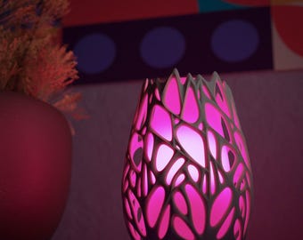 May include: A decorative, illuminated vase with a white, openwork design, showcasing a vibrant pink glow. The vase has a unique, organic shape and is placed near a red vase with dried flowers.