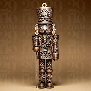 Op de afbeelding: Versierde bronzen notenkraker figuur met een hoge hoed en staf. Het figuur heeft gedetailleerde gravures en een lus om op te hangen. Een klassieke vakantiedecoratie.