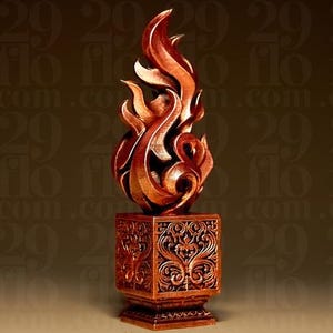 Puede incluir: Una escultura de color cobre con una base cuadrada que presenta intrincados patrones de volutas simétricas. Sobre la base se eleva una forma de llama estilizada en tres dimensiones con bordes curvos y un acabado metálico.