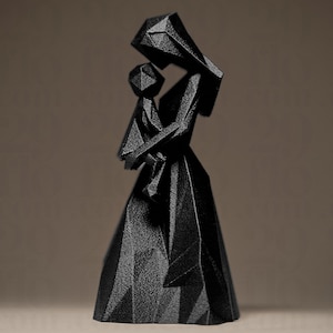 May include: A black geometric sculpture depicting a mother and child. The figures are formed from angular planes, giving a modern, abstract appearance. The sculpture has a textured surface and is set against a neutral backdrop.