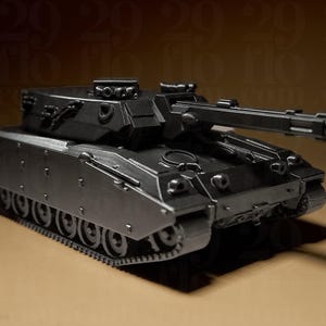 Könnte beinhalten: Ein detaillierter, dunkelgrauer Spielzeugpanzer mit langem Lauf und mehreren Rädern. Das Design des Panzers umfasst komplizierte Details an Karosserie und Turm, die ein realistisches Aussehen zeigen. Das Bild ist gut beleuchtet und hebt die Merkmale des Panzers hervor.