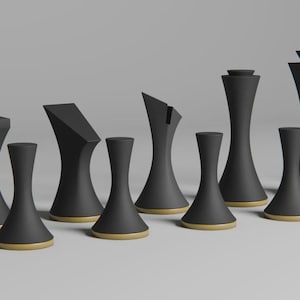 Op de afbeelding: Een set moderne zwarte schaakstukken met goudkleurige bases. De stukken hebben unieke geometrische vormen, waaronder vierkante, schuine en cilindrische ontwerpen. De schaakset wordt gepresenteerd op een lichtgrijze ondergrond.