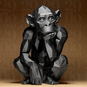Könnte beinhalten: Schwarze geometrische Skulptur eines Affen in sitzender Position, das Kinn auf der Hand ruhend. Die Skulptur hat ein facettiertes Design, das ihr ein modernes, eckiges Aussehen verleiht. Der Ausdruck des Affen wirkt nachdenklich.