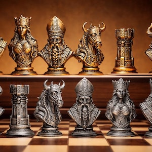 May include: A set of twelve chess pieces arranged on a board, featuring six gold-toned and six silver-toned figures. The pieces are sculpted as detailed busts of kings, queens, bishops, knights, rooks, and horned warriors with intricate textures.