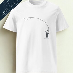 Könnte beinhalten: Weißes T-Shirt mit einer grauen Silhouette einer Person beim Fliegenfischen. Das Design zeigt einen Fischer, der eine Leine auswirft. In der oberen linken Ecke steht der Text "XPERTANCE FLY FISHING APPAREL & GIFTS" in Marineblau.
