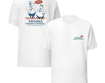 May include: White t-shirts with a graphic design. The front of the shirt has the text "TAVERNA NIKOLAOU & GEORGIOU". The back of the shirt features two cartoon chefs and the text "AUTHENTIC GREEK FOOD".