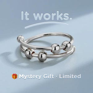 May include: A silver-colored fidget ring with three small, round beads on the top band and three on the bottom band. The text "It works." is above the ring, and "Mystery Gift - Limited" is below.