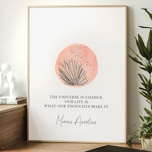 May include: A framed art print with a minimalist design. It features a peach-colored circle with black line art and the quote "THE UNIVERSE IS CHANGE. OUR LIFE IS WHAT OUR THOUGHTS MAKE IT." by Marcus Aurelius.