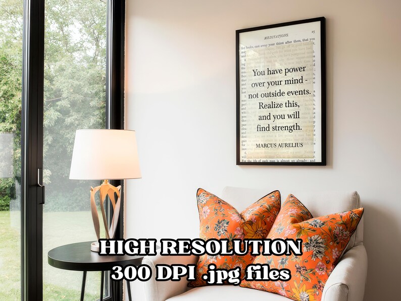 Puede incluir: Un cuadro enmarcado con una cita de Marco Aurelio: "Tienes poder sobre tu mente, no sobre los acontecimientos externos. Date cuenta de esto y encontrar&aacute;s la fuerza". El cuadro cuelga sobre un sill&oacute;n blanco con cojines florales naranjas.