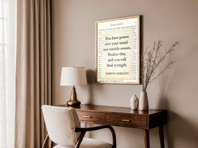 Puede incluir: Impresi&oacute;n enmarcada con la cita "Tienes poder sobre tu mente, no sobre los acontecimientos externos. Date cuenta de esto y encontrar&aacute;s la fuerza" de Marco Aurelio. Sobre un escritorio de madera con l&aacute;mpara y silla.