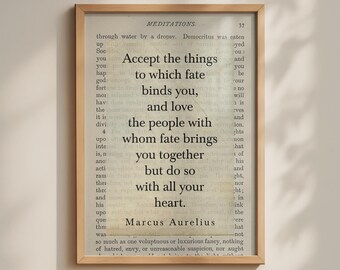 May include: A framed wall art print featuring a page from the book Meditations by Marcus Aurelius. The text reads: Accept the things to which fate binds you, and love the people with whom fate brings you together but do so with all your heart.