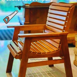 May include: A wooden outdoor chair with a slatted back and seat. The chair has armrests and a sturdy frame. The chair is made of a light brown wood. The text "@ClickCreateCompany" is in the top left corner.