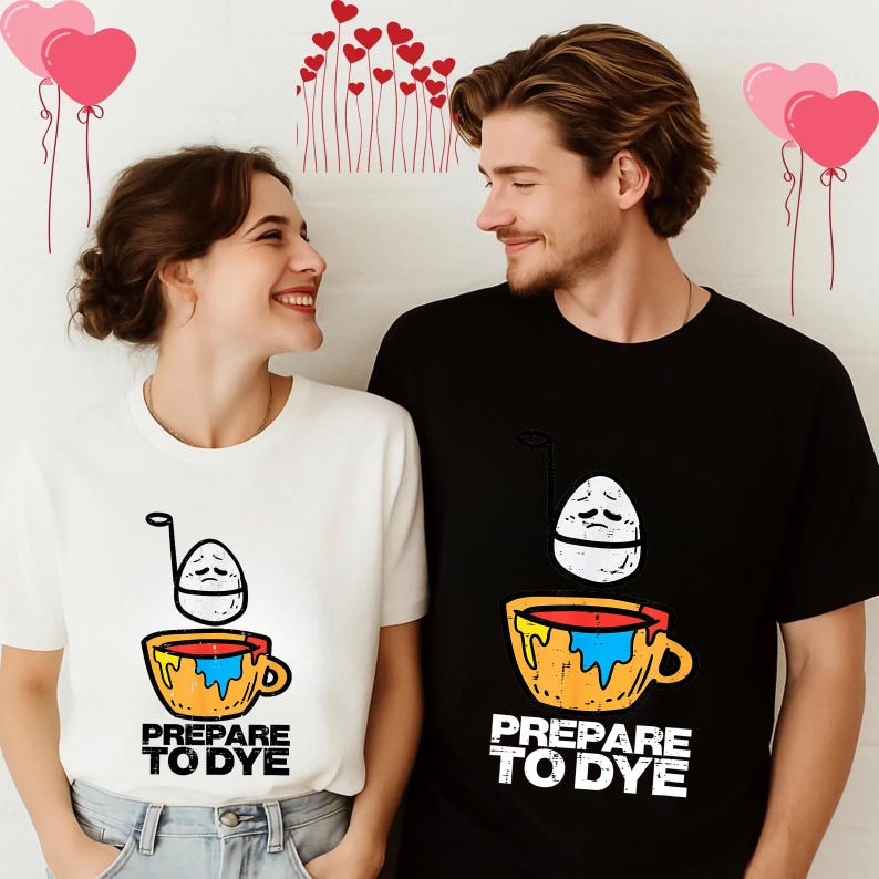 May include: White and black t-shirts with a graphic of an egg in a cup, with the text "PREPARE TO DYE". The egg has a sad face. The cup is yellow and orange with blue and red paint. The shirts are worn by a couple.