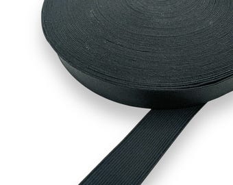 Puede incluir: Un rollo de cinta elástica negra. La goma elástica está bien enrollada y parece estar hecha de una tela tejida duradera. La cinta mide aproximadamente 2,5 cm de ancho y es adecuada para diversos proyectos de costura y manualidades.
