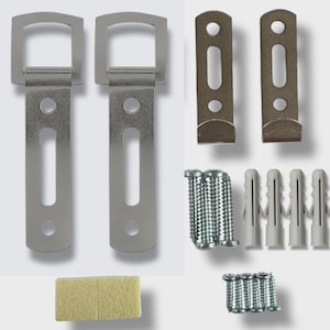 May include: A hardware kit comprising two silver metal brackets with a rectangular loop, two smaller brackets, screws, and wall plugs. Also included is a small, rectangular, beige foam pad. The components are arranged on a white background.