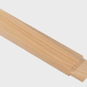 May include: Two unfinished wooden boards, one overlapping the other. The boards are light brown with visible wood grain. The image is taken at an angle, showing the side profile of the boards.