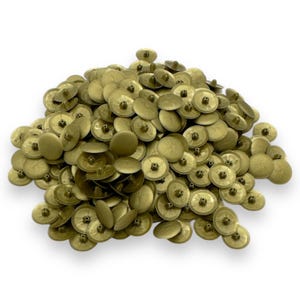 May include: A collection of brass-coloured upholstery tacks. Each tack features a flat, round head and a short, pointed shank. The tacks are scattered, creating a textured surface. The colour is a muted gold, with a slightly aged appearance.