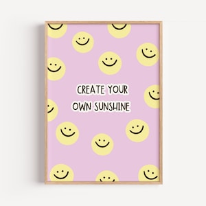 Könnte beinhalten: Ein gerahmter Wandkunstdruck mit hellviolettem Hintergrund und einem wiederkehrenden Muster aus gelben Smileys. In der Mitte befindet sich der Text "CREATE YOUR OWN SUNSHINE" in einer dunkelbraunen, abgerundeten Schrift mit weißem Rand.