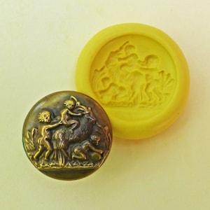 May include: A vintage brass button with a raised design of three children playing on a goat. The button is round and has a smooth, polished surface.