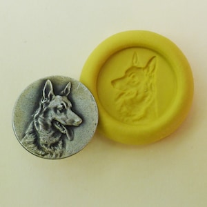 May include: A silver-colored metal button with a detailed profile of a German Shepherd dog. The button is next to a yellow silicone mold with the same dog profile.