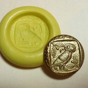 May include: A yellow silicone mold with a raised design of an owl with leaves. A gold-colored metal owl with leaves is shown next to the mold.