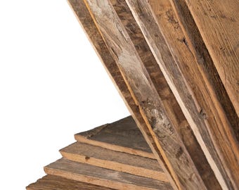May include: A stack of rectangular wooden boards with a weathered, brown finish. The boards are arranged in two sections, with one group lying flat and another group fanned out at an angle, displaying visible wood grain and natural textures.