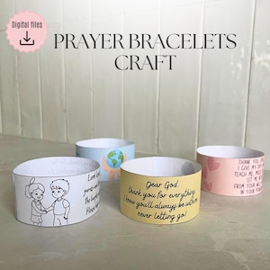 Può includere: Quattro braccialetti di preghiera di carta con diversi disegni. Un braccialetto ha un disegno di due bambini che si tengono per mano, un altro ha un globo e un altro un motivo a cuore. Il quarto braccialetto ha il testo "Dear God, thank you for everything."