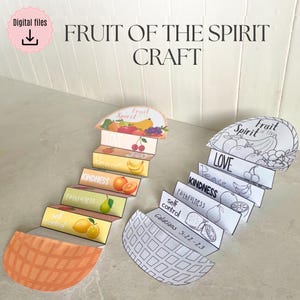 May include: A craft project featuring two paper displays with the text "Fruit of the Spirit." One is coloured with illustrations of fruit, and the other is a black and white outline. Each display has labelled sections.