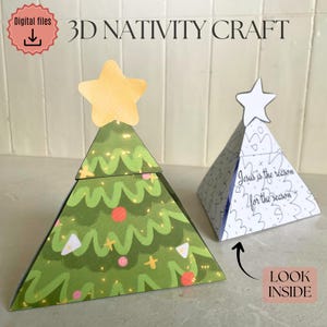 Puede incluir: Dos modelos de papel 3D de la Natividad. Uno tiene forma de árbol de Navidad verde con una estrella amarilla en la parte superior. El otro es una forma de pirámide blanca con el texto "Jesus is the reason for the season".