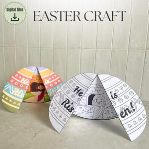 Op de afbeelding: Twee paasknutsel eivormige papieren uitsparingen. Eén is gekleurd met pastelstrepen en een Jezus-illustratie. De andere is een zwart-wit lijntekening met de tekst "Hij is verrezen!" en een Jezus-illustratie. De tekst "Easter Craft" staat bovenaan.