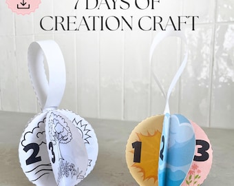 May include: Two spherical paper ornaments with white ribbon hangers. One is black and white with numbers and line drawings. The other has colorful illustrations of the sun, clouds, and flowers, with the numbers 1, 2, and 3. Text reads "7 DAYS OF CREATION CRAFT".