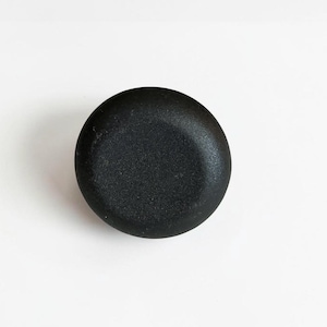 May include: A circular, matte black knob with a smooth, slightly domed surface. The object features a uniform, solid dark finish and a simple, rounded profile, presenting a clean and functional design suitable for various hardware applications.