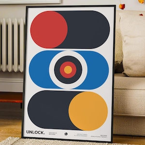 May include: A framed vertical poster featuring three stacked horizontal pill-shaped forms on a white background. The top shape is red and dark gray, the middle is blue with a central target motif, and the bottom is dark gray and yellow. Text reads UNLOCK.