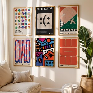 K&ouml;nnte beinhalten: Sechs gerahmte Kunstdrucke mit farbenfrohen abstrakten Designs und Text h&auml;ngen an einer wei&szlig;en Wand. Die Drucke zeigen geometrische Formen, Text und ein Smiley-Gesicht. Ein Sofa, ein Kissen und eine Topfpflanze befinden sich im Vordergrund.