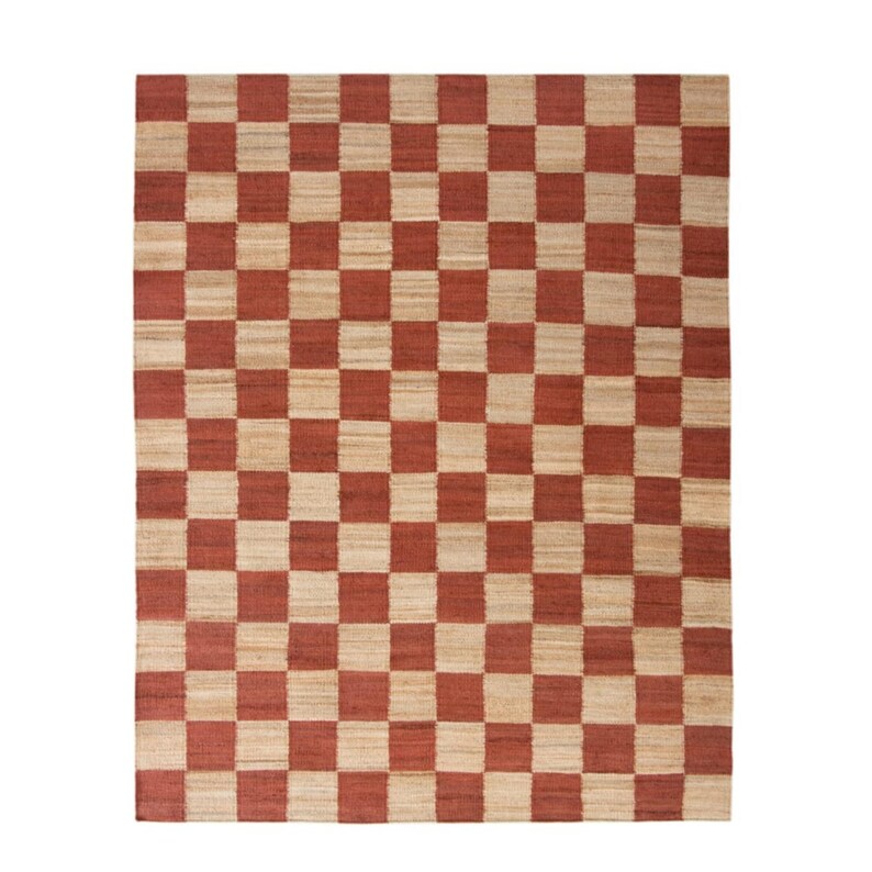May include: A rectangular area rug with a checkerboard pattern. The rug features alternating squares of a reddish-brown color and a natural beige color. The rug is made of a woven material.