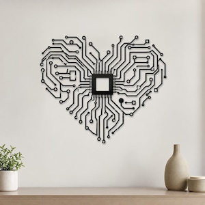 May include: A black wall art piece shaped like a heart, constructed from intricate circuit board patterns and lines. At the center of the heart design is a solid square component, with various pathways and nodes extending outward to form the heart shape.