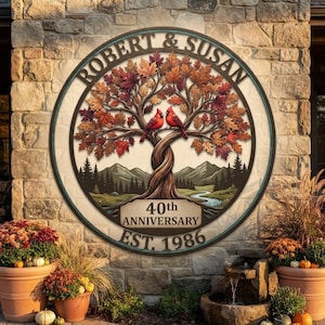 May include: A circular wall sign featuring a central tree with autumn-colored leaves and two red cardinals perched on branches. The text reads ROBERT & SUSAN, 40th ANNIVERSARY, and EST. 1986. The background depicts a mountain landscape with a river.