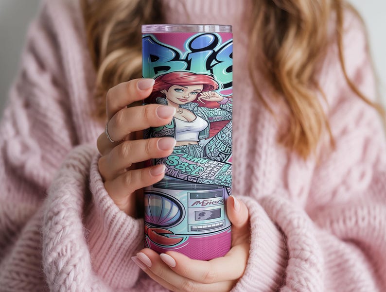Pu&ograve; includere: Un bicchiere cilindrico in acciaio inossidabile con un vivace design in stile graffiti. L'illustrazione mostra un personaggio dei cartoni animati con capelli rossi, un top bianco e una giacca fantasia, sopra una grafica di un boombox retr&ograve; con conchiglia.
