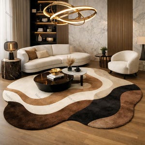 May include: A modern living room featuring a large, abstract-shaped rug in shades of brown, beige, and black. The room includes a white sofa, a round coffee table, and a curved armchair. A decorative light fixture hangs from the ceiling.