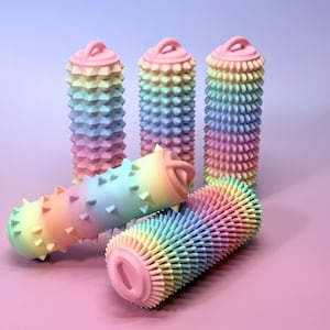 May include: Several colourful, cylindrical objects with textured surfaces and loop handles. The objects are arranged in a gradient of pastel colours, including pink, blue, yellow, and green. The design features repeating, spiky or ridged patterns.
