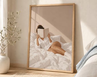 May include: A framed vertical wall art print featuring a person lying on a white bed, wearing a white button-down shirt and white socks, while holding an open book in front of their face. The scene is set against a neutral beige background.