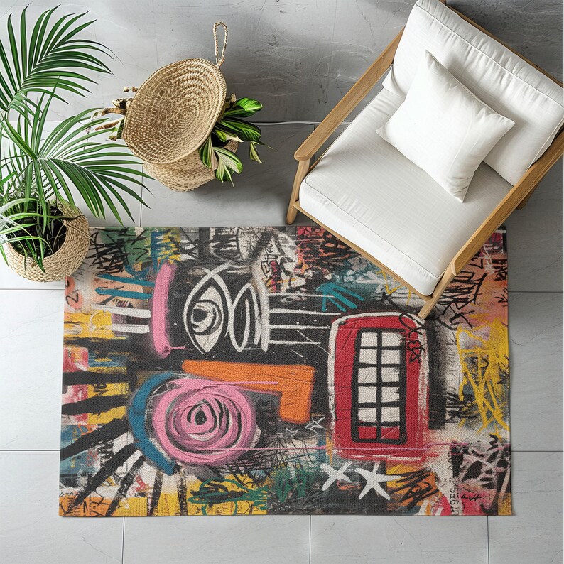 May include: A colorful area rug with a graffiti-style design. The rug features a red telephone booth, a pink rose, and various abstract shapes in black, white, orange, yellow, and blue. The rug is rectangular.