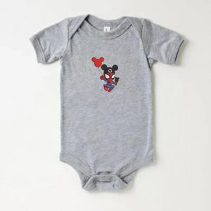 May include: A gray baby onesie featuring a cartoon character that is a hybrid of Spider-Man and Mickey Mouse. The character is holding a red balloon. The onesie has short sleeves and a snap closure.