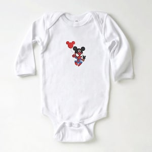 May include: White long-sleeve baby bodysuit featuring a cartoon illustration of a Spider-Man character with Mickey Mouse ears holding a red balloon. The character is wearing a red and blue Spider-Man suit.