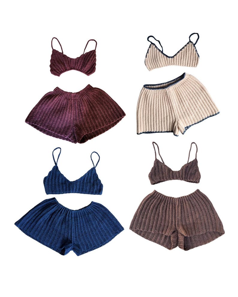 May include: Four sets of knitted two-piece outfits. Each set includes a matching top with spaghetti straps and high-waisted shorts. The sets are in shades of burgundy, beige with navy trim, navy blue, and brown.