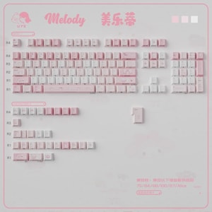 May include: A set of pink and white keyboard keycaps arranged on a white surface. The keycaps are in various sizes and shapes, with some featuring printed characters. The word "Melody" is written in pink script, and Chinese characters are also visible.
