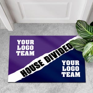 May include: Rectangular doormat with a purple and navy blue background, divided diagonally by a white stripe. The text "HOUSE DIVIDED" is in bold black letters. The words "YOUR LOGO TEAM" appear in white on both sides.