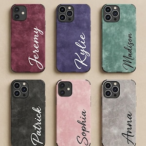 Puede incluir: Seis fundas para smartphone con un acabado texturizado similar al ante en burdeos, morado, verde azulado, carbón, rosa claro y gris. Cada funda presenta un nombre personalizado impreso en letra cursiva: Jeremy, Kylie, Madison, Patrick, Sophia y Anna.